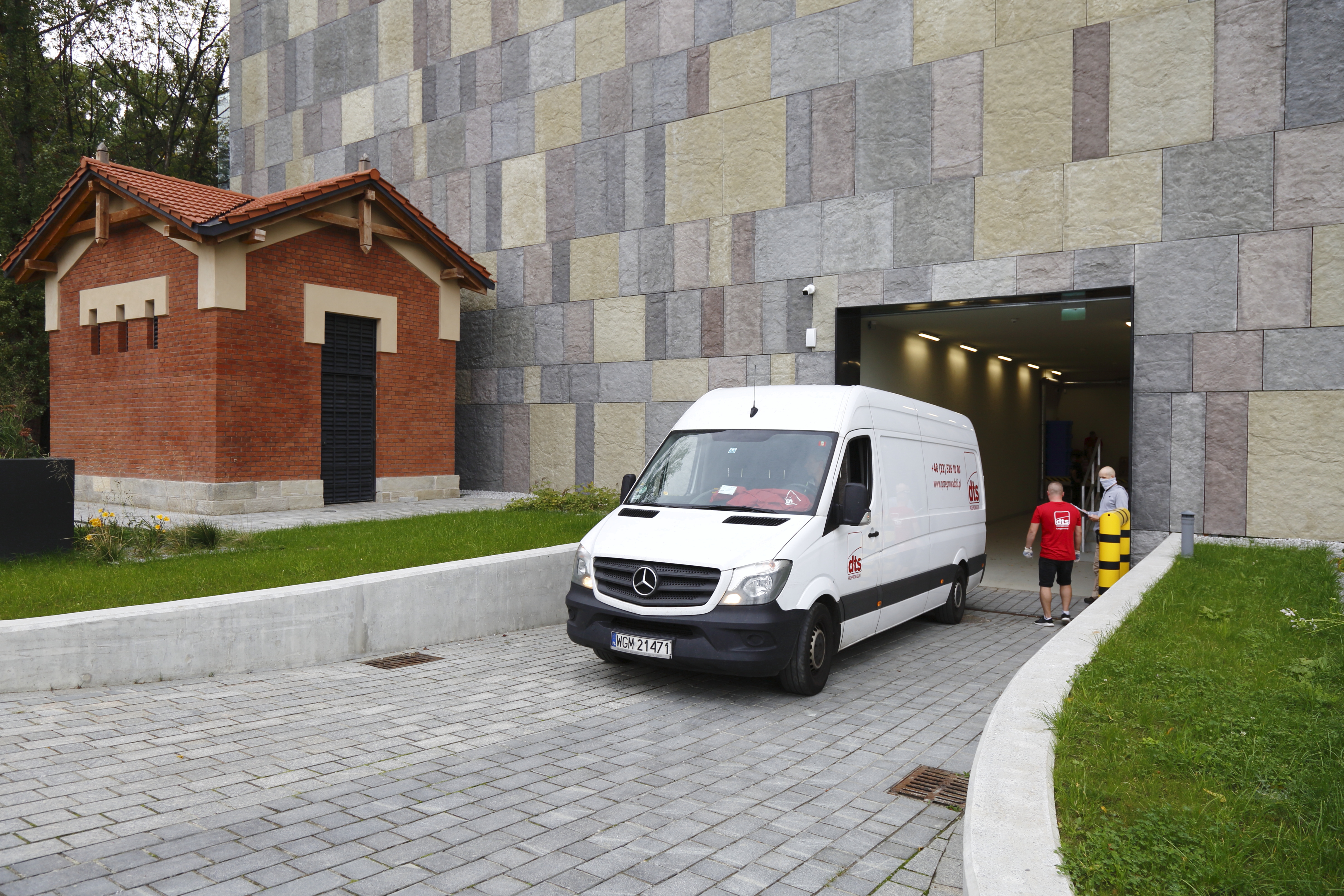 Samochód z transportem archiwaliów wjeżdża do nowego budynku.