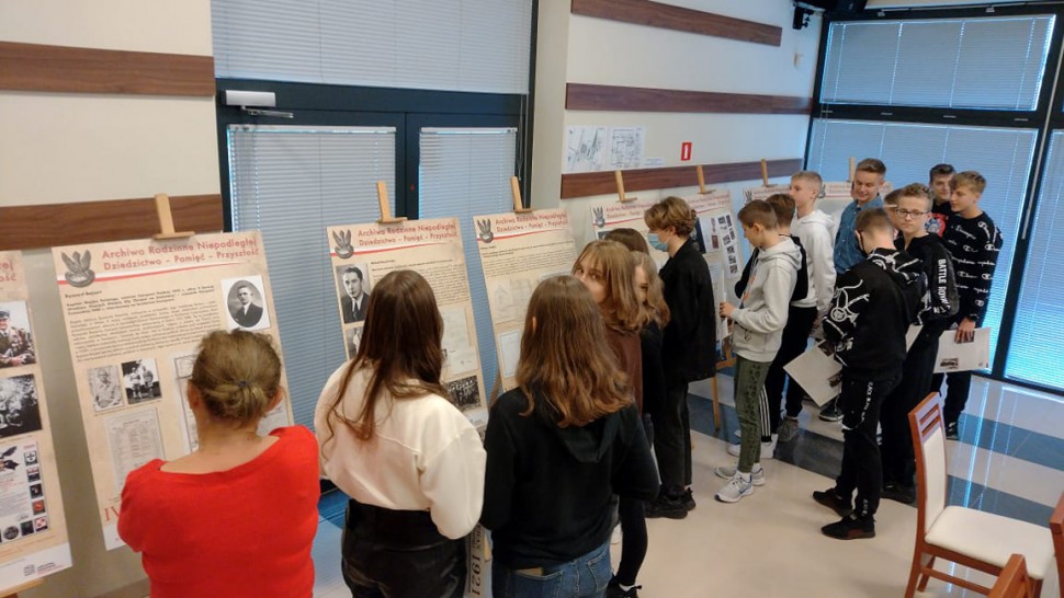 Grupa uczniów przy planszach wystawy.