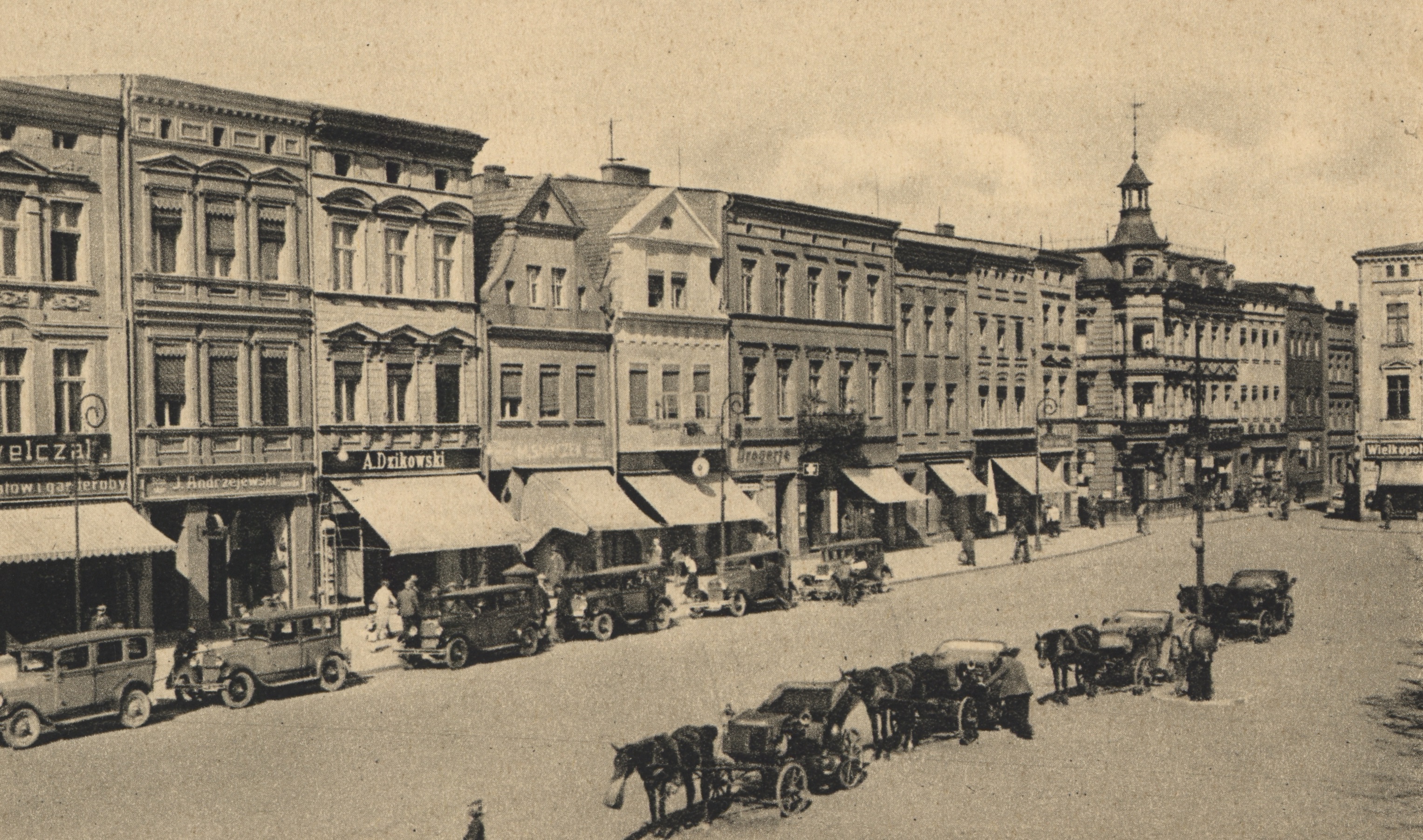 Zdjęcie archiwalne rynku w Lesznie, widoczne kamienice, samochody i dorożki. 