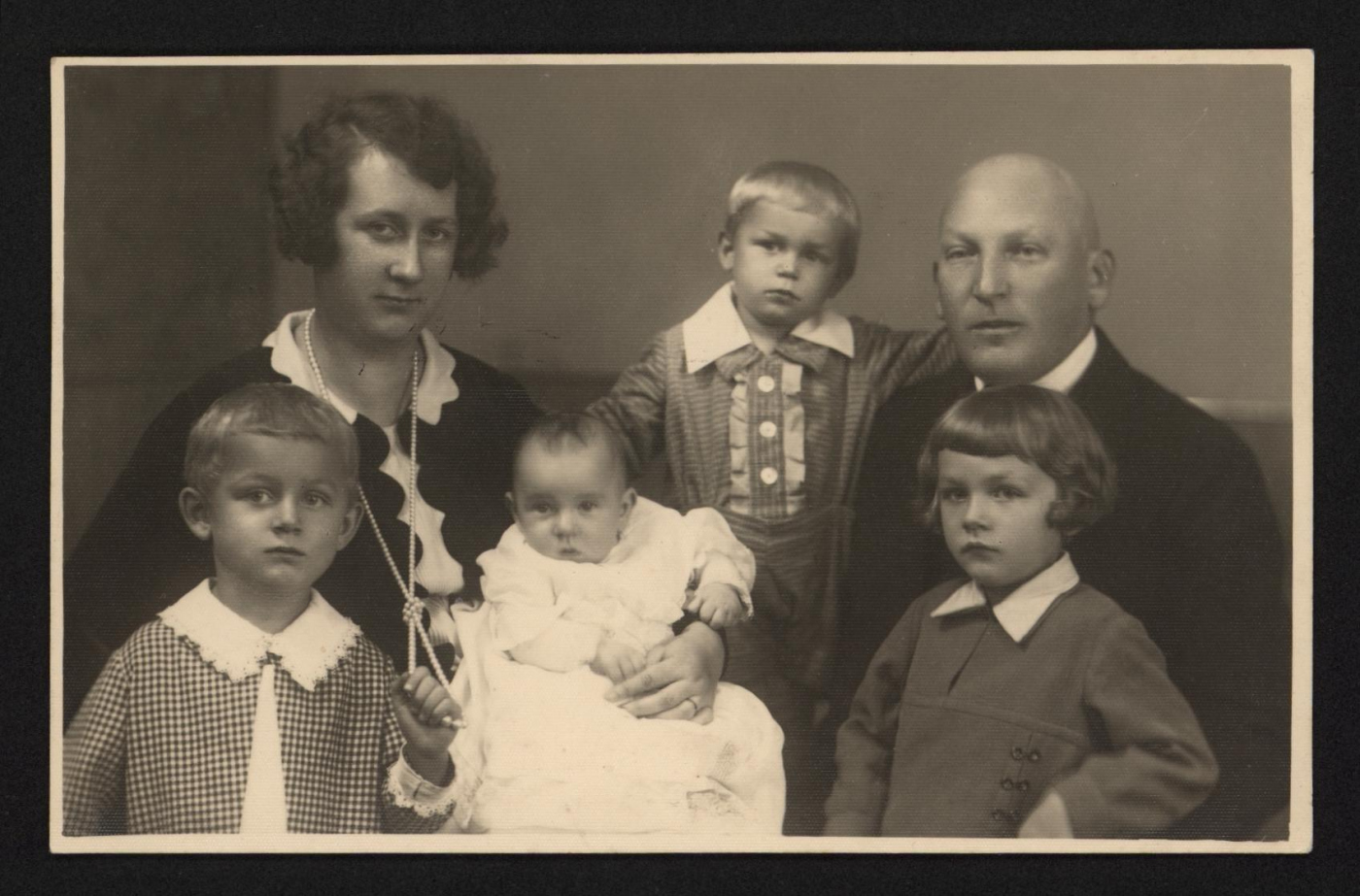 Fotografia rodzinna, widoczni rodzice i czworo dzieci. 