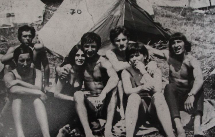 Grupa młodych osób, w tle namiot.