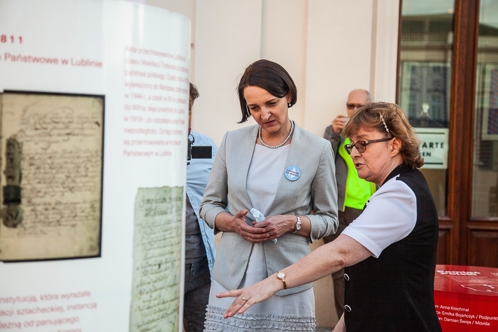 Kurator wystawy Anna Krochmal opowiada i wskazuje minister Gawin obiekty na wystawie. 