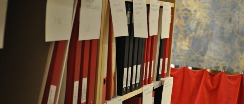 Czerwone i czarne segregatory z dokumentami.