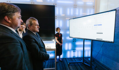 Dyrektor Pietrzyk i premier Gliński oglądają prezentację serwisu na dużym ekranie.