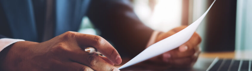 Sylwetka mężczyzny siedzącego przy stole z dokumentami