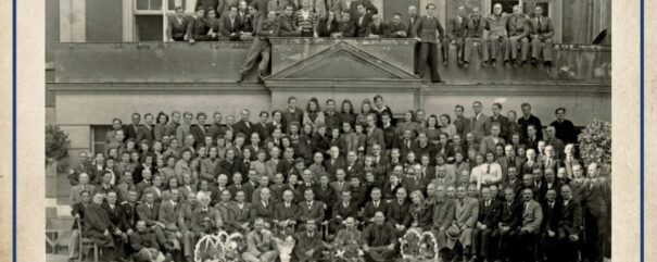 Fotografia grupowa pracowników magistratu w Grudziądzu z 1946 r. z zasobu Archiwum Państwowego w Toruniu. Pracownicy pozują przed wejściem do budynku i na balkonie.