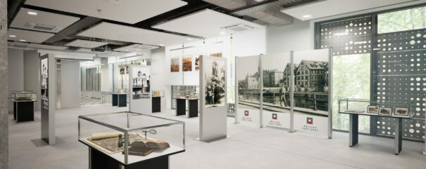 Projekt graficzny sali wystawowej w budynku archiwum. Widoczne są gabloty z eksponatami oraz tablice z opisami i historycznymi zdjęciami.