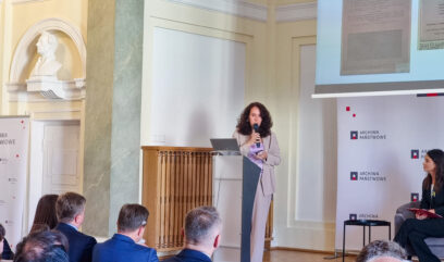 Prof. Olga Kulinich przemawia na podium do mikrofonu.