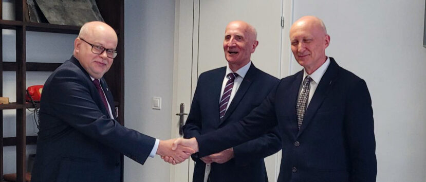 Dyrektor Wojkowski i dyrektor Filipowicz podają sobie ręce, obok stoi dyrektor Radziwonowicz.