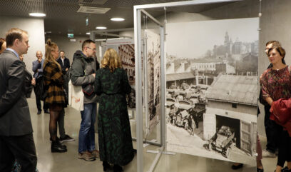Goście zwiedzają wystawę w sali wystawowej.