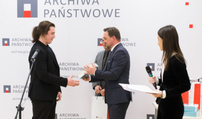 Laureat odbiera książkę z rąk Naczelnego Dyrektora Archiwów Państwowych Pawła Pietrzyka.