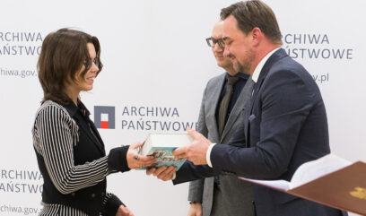 Laureatka odbiera książkę z rąk Naczelnego Dyrektora Archiwów Państwowych Pawła Pietrzyka.