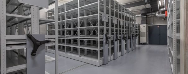 A repository inside the building. Visible empty archive shelves.