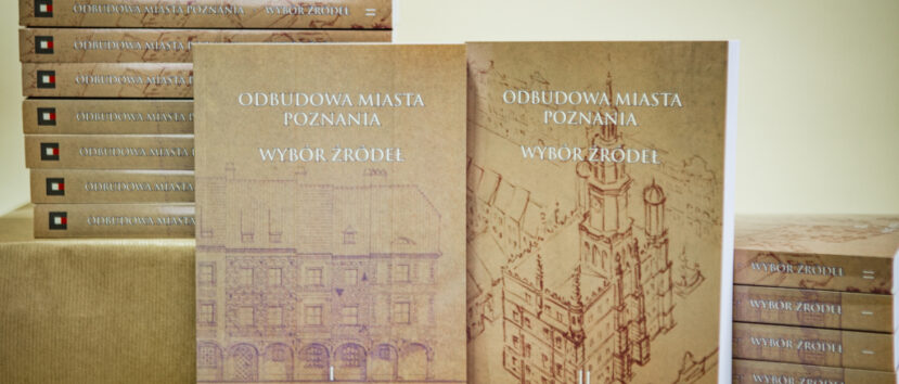 15 egzemplarzy książki „Odbudowa miasta Poznania. Wybór źródeł”. Dwa egzemplarze ułożone w pozycji stojącej, reszta leży w dwóch kupkach