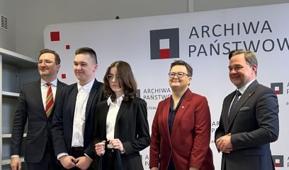 Zdjęcie grupowe. 5 osób na zdjęciu, za nimi ścianka z logotypem Archiwa Państwowe Archiwum Akt Nowych.