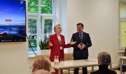 Ministra Scheuring-Wielgus i dyrektor Pietrzyk stoją na środku sali przed publicznością.