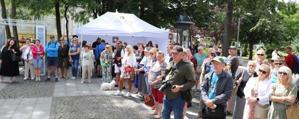 Publiczność wydarzenia stoi na placu.