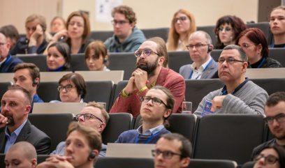 Aula wykładowa. Publiczność siedzi na auli.