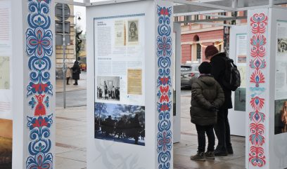 Przechodnie oglądają wystawę.