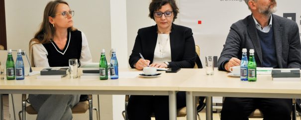 Członkowie rady siedzą za stolikiem.