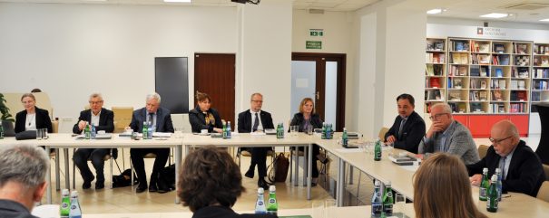 Członkowie rady siedzą za stolikiem.