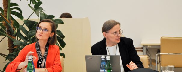 Członkowie rady siedzą za stolikiem.