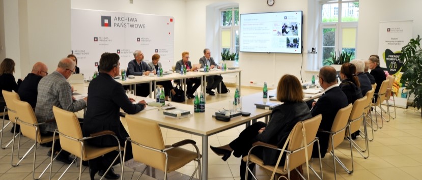 Członkowie rady siedzą za stolikiem.