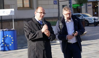Dwie osoby stoją na bruku. Przemawia do mikrofonu dyrektor Archiwum Państwowego w Lublinie Krzysztof Kołodziejczyk.