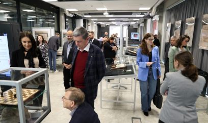 Tłum w sali wystawowej ogląda wystawę.
