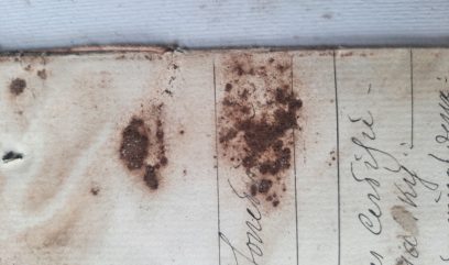 Fragment karty z brązowym nalotem zasłaniającym tekst.