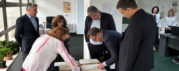 6 osób przegląda dokumenty rozłożone na stoliku.