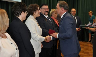 Dyrektor Pietrzyk wymienia uścisk dłoni z odznaczoną.