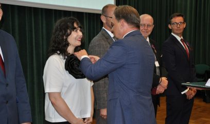 Dyrektor Pietrzyk przypina Brązowy Krzyż Zasługi.