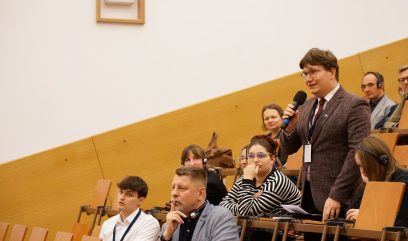 Publiczność siedzi na auli. Mężczyzna z publiczności zadaje pytanie.