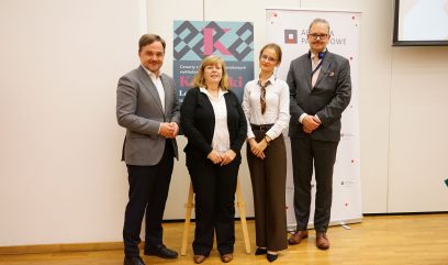 Aula wykładowa. Zdjęcie grupowe 4 osoby na scenie.