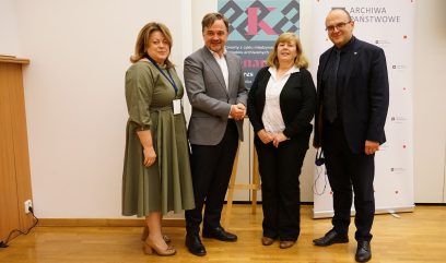 Aula wykładowa. Zdjęcie grupowe 4 osoby na scenie.