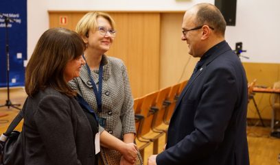 3 osoby rozmawiają w auli.