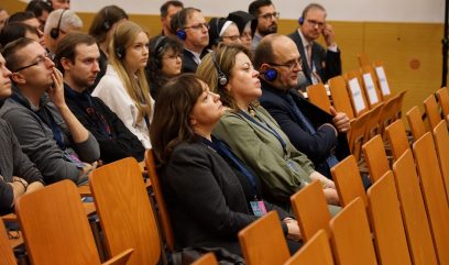 Aula wykładowa. Publiczność siedzi na auli.