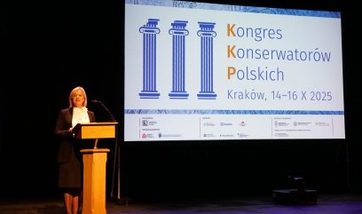 Wiceminister Bożena Żelazowska stoi na scenie za mównicą.