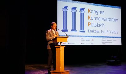 Naczelny Dyrektor Archiwów Państwowych dr Paweł Pietrzyk stoi na scenie za mównicą.