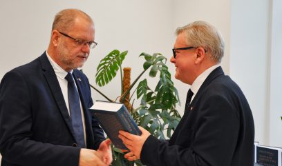 Jacek Krochmal wręcza egzemplarz publikacji dyrektorowi Krawczukowi.