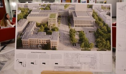 Hol budynku. Na tablicy na stelażu widoczny projekt architektoniczny.