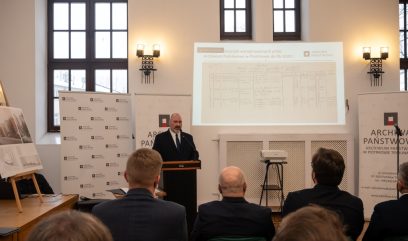 Dyrektor Matuszak stoi za mównicą i przemawia do publiczności.