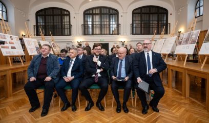 Publiczność siedzi na krzesełkach na sali.