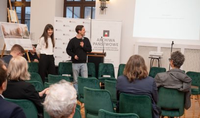 Dwie osoby na scenie mówią do mikrofonów.