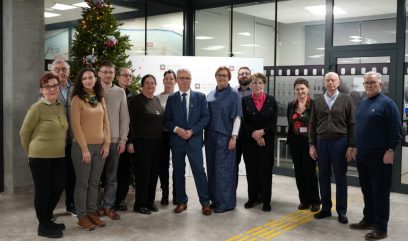 Zdjęcia zbiorowe 14 osób. Z tylu stoi choinka.