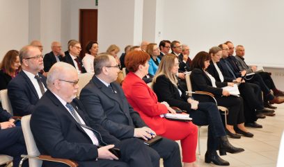 Kilkadziesiąt osób siedzi na sali.