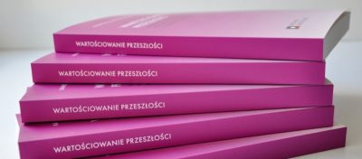 Pięć ułożonych w stos różowych książek z białym polskim napisem WARTOŚCIOWANIE PRZESZŁOŚCI na grzbietach. Książki są starannie ułożone, każda leży płasko i lekko przekrzywiona, z częściowo widoczną górną okładką. Tło jest białe.